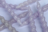 Close-up of purple twisted candles on a light purple background