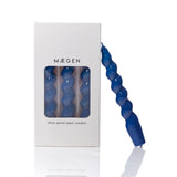 Blue spiral taper candle in front of a Maegen branded box on a white background