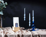 Decorative candles with a blue and white color scheme on a dark background